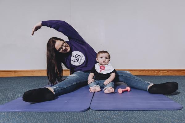 Female sat on the floor with a child between her legs